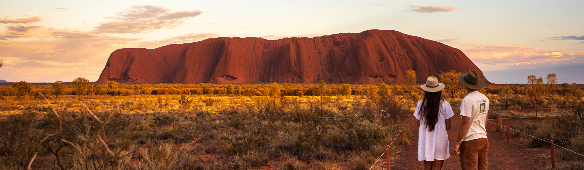 A couple looking out to Uluru during sunset, Northern Territory